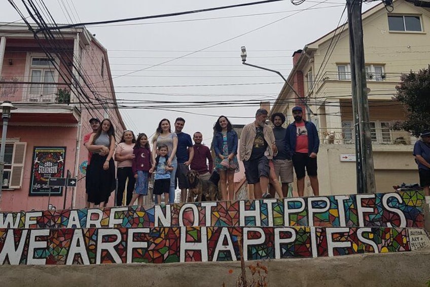 A group of people standing in front of a colorful sign with text. 2