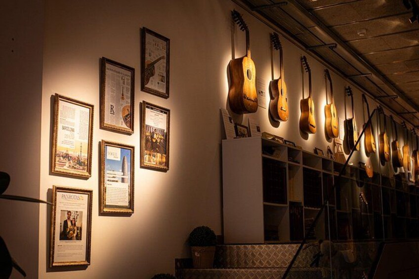 Framed documents and guitars on a wall. 5
