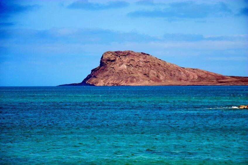 Une île rocheuse au milieu d’eaux d’un bleu limpide. 5