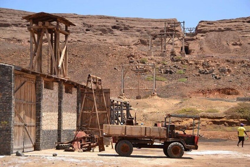 Un chantier de construction avec une structure en bois, un camion et une personne qui marche. 2
