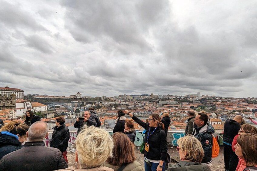 A group of people on a rooftop overlooking a cityscape with historic buildings and a bridge. 2