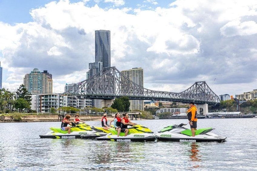 A rowing team on a river with a city skyline and a bridge in the background. 5