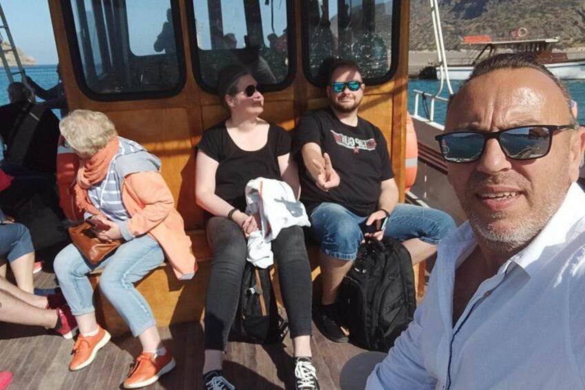 En gruppe mennesker på en båd foran et bjerglandskab. 5