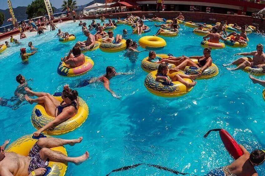 Personas flotando en una piscina sobre flotadores de colores. 3