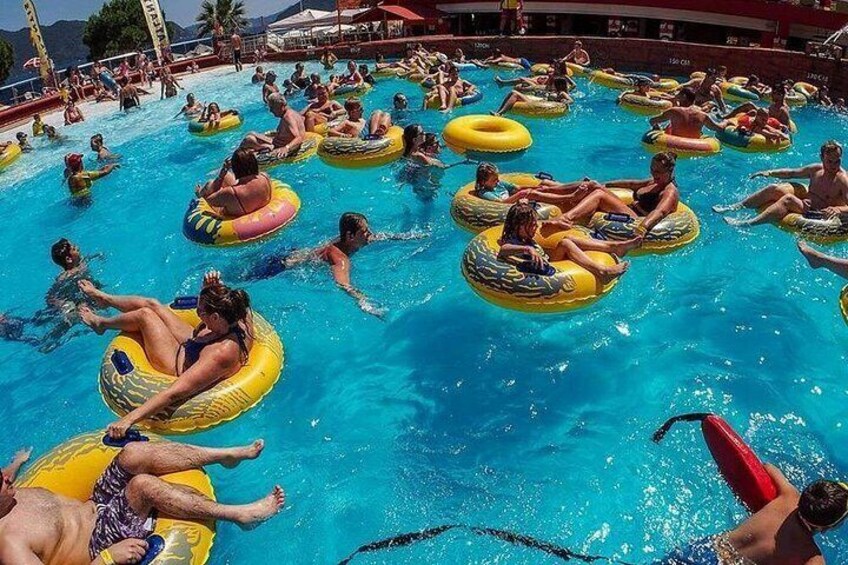 Una piscina con gente flotando en flotadores de colores. 1