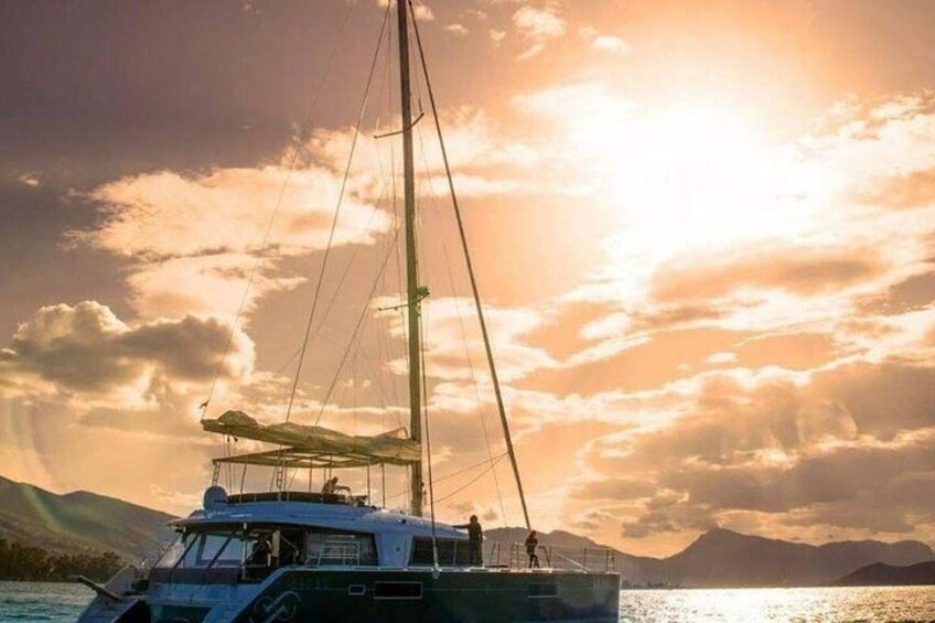 A sailboat on calm waters with a sunset in the background. 1