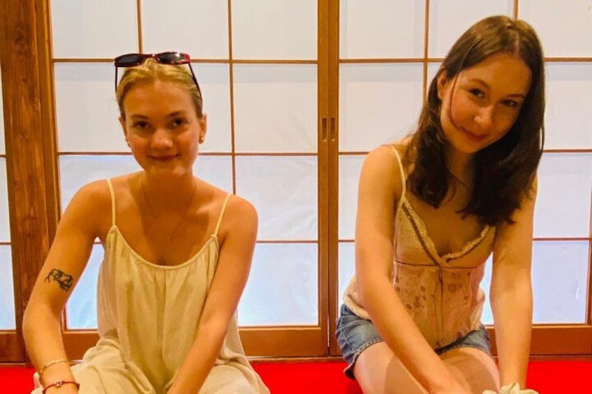 To personer sidder foran en traditionel japansk skydedør. 4