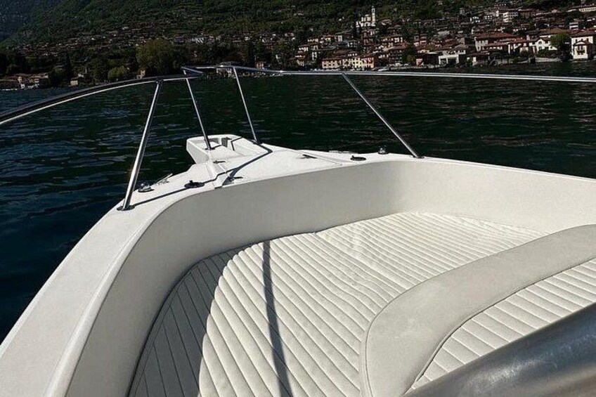 A boat's interior with a white cushioned seat and a metal railing. 2