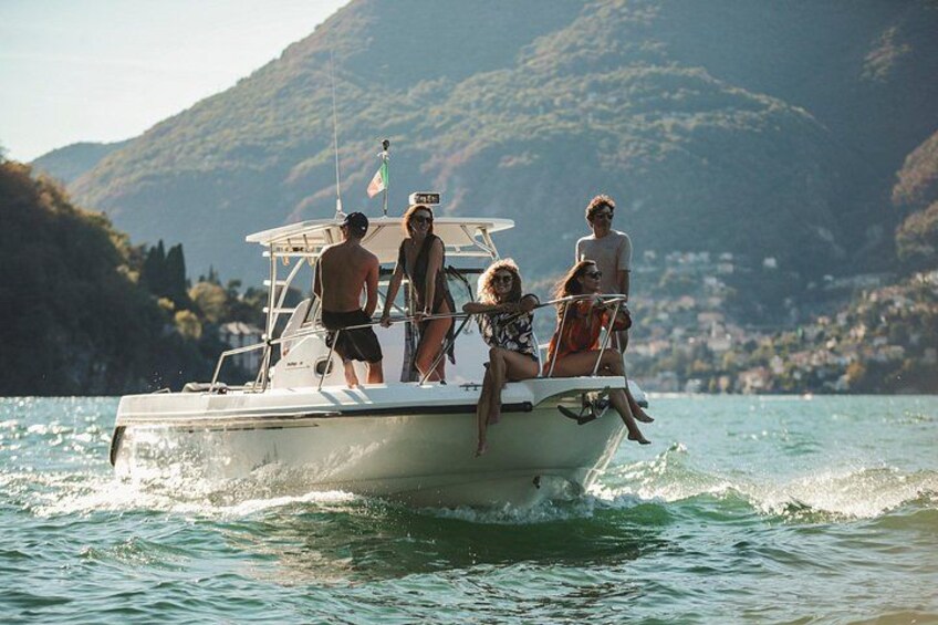 A group of people on a boat in a body of water with hills in the background. 1