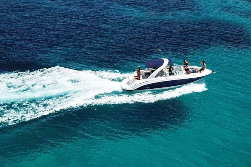 Een speedboot met passagiers vaart door helder turquoise water. 3