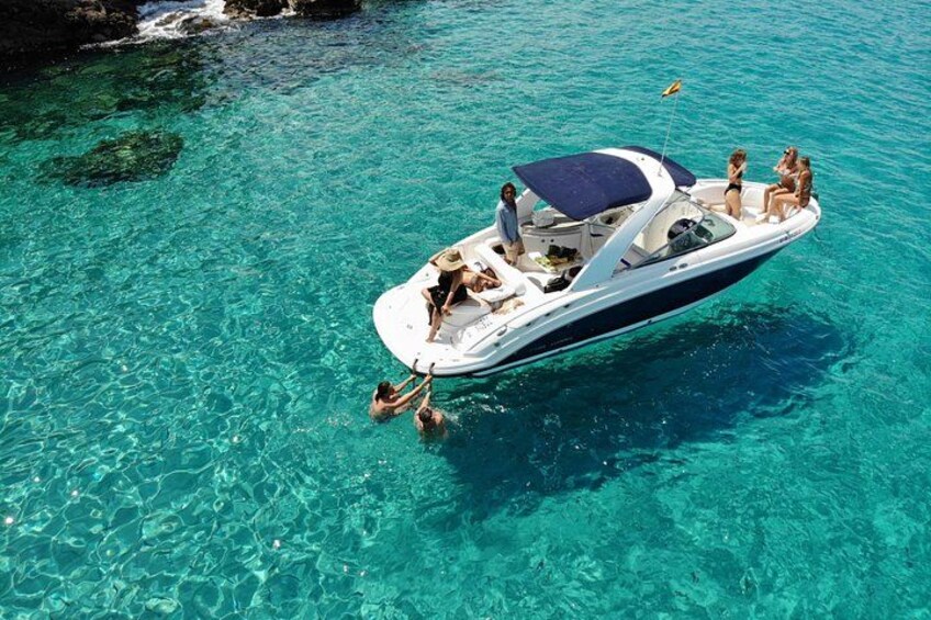 Een boot met mensen in helder turquoise water. 1
