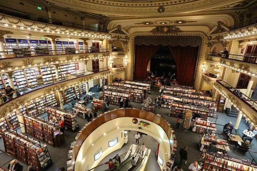 A large, ornate library with multiple levels of bookshelves and a central circular reading area. 2