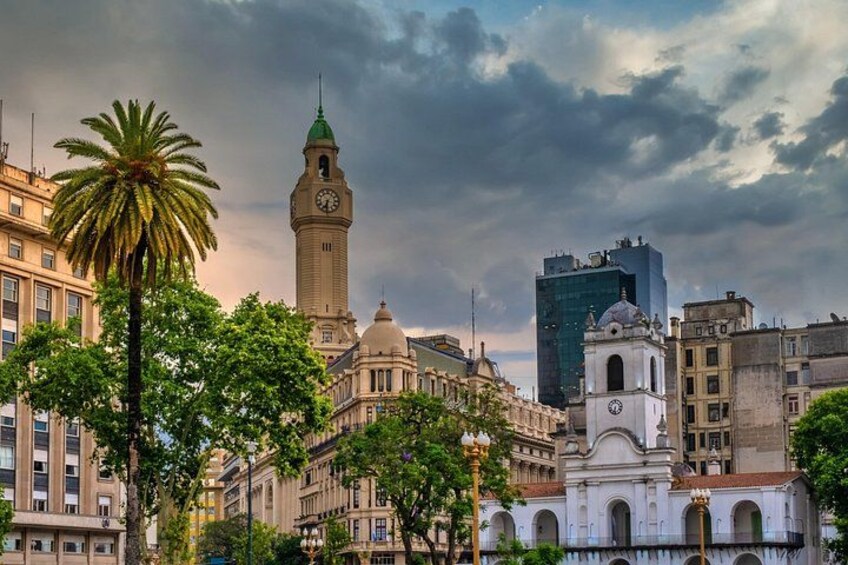 A cityscape with a prominent clock tower, a modern skyscraper, and classical architecture. 4