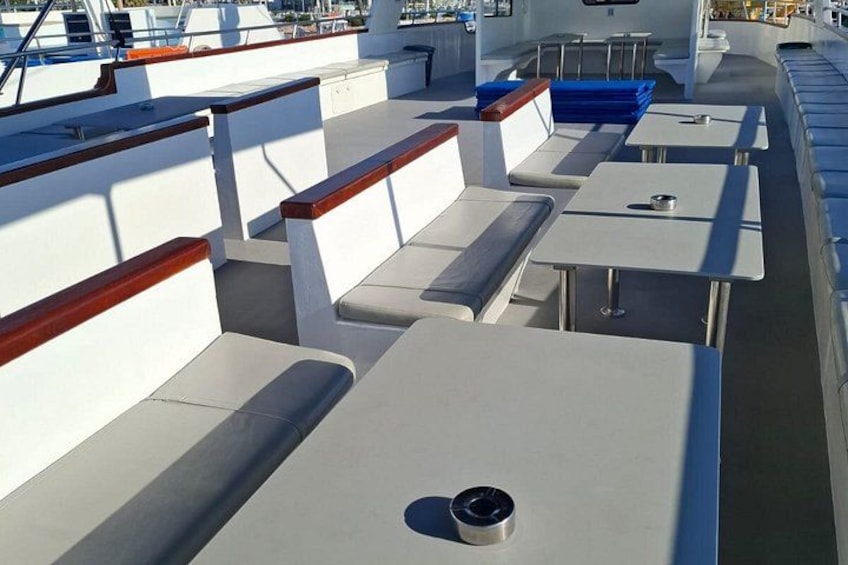 A boat deck with seating and tables. 3