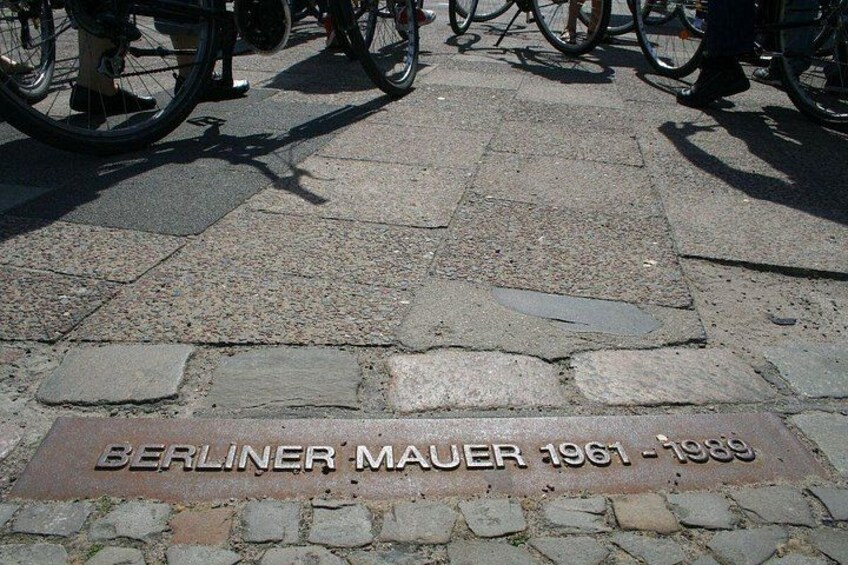 Een geplaveid straatje met een plaquette waarop staat 'BERLINER MAUER 1961-1989'. 3