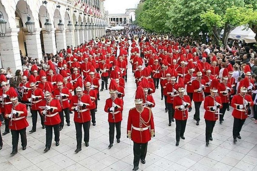 Un grand groupe de personnes vêtues d’uniformes rouges, marchant en formation. 5