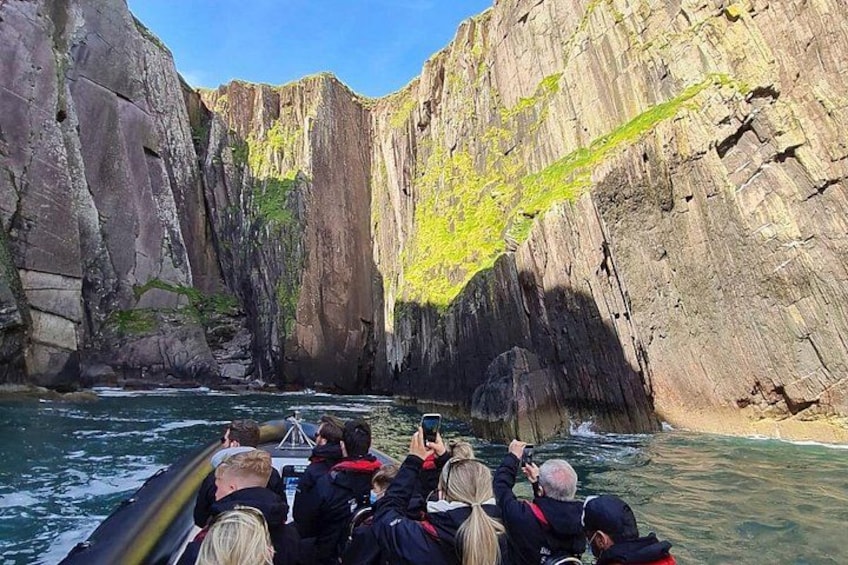 A boat navigating a narrow canyon with steep rock walls. 2