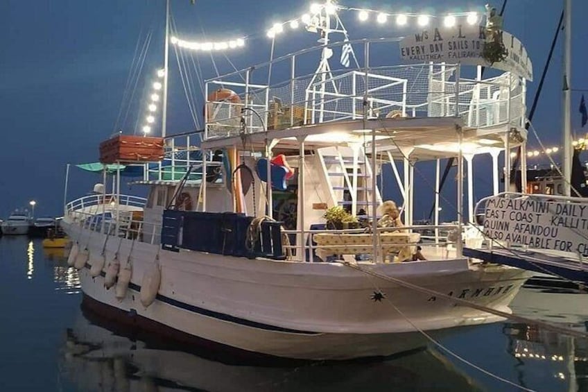 A boat docked at a marina with lights and signage. 1