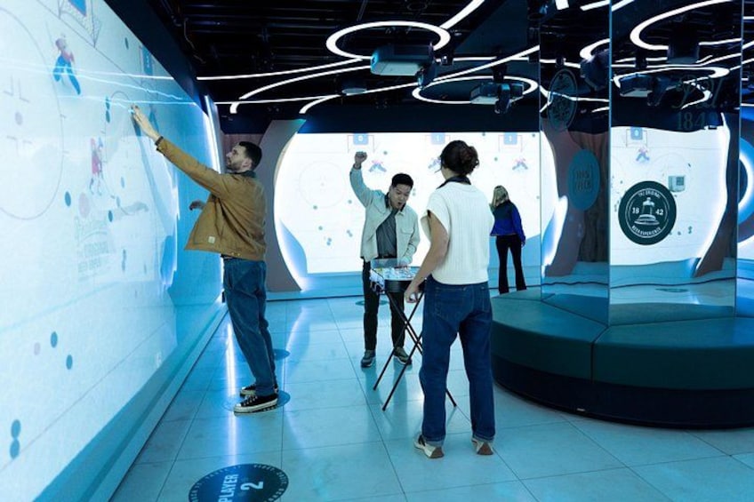 A futuristic room with digital displays and people interacting with the content. 2