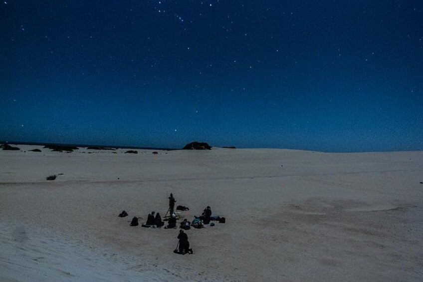 A group of people gathered in a snowy landscape under a starry night sky. 2
