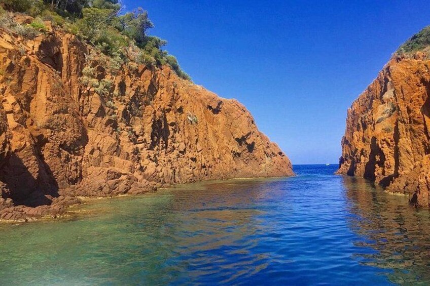 A coastal landscape with rocky cliffs and clear blue water. 5