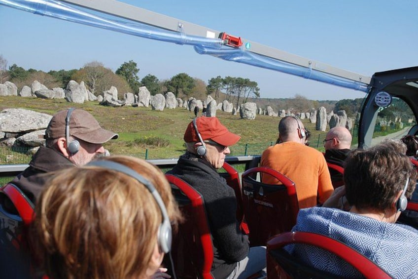 People on a guided tour vehicle observing a large rock formation. 2