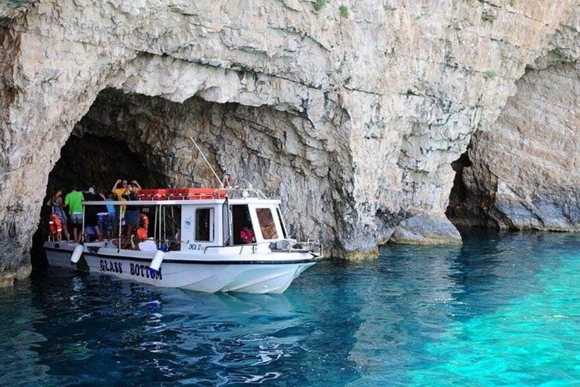 A boat named 'GLASS BOTTOM' docked at a cave entrance. 5