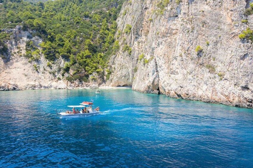 Un bateau sur une mer bleue et limpide, avec des falaises rocheuses en arrière-plan. 4