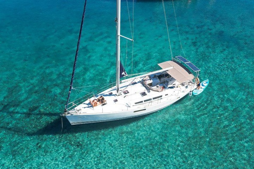A sailboat on clear turquoise water. 1