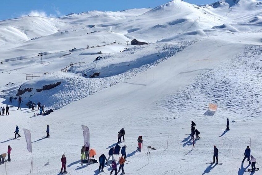 A snowy mountain slope with skiers and snowboarders. 4