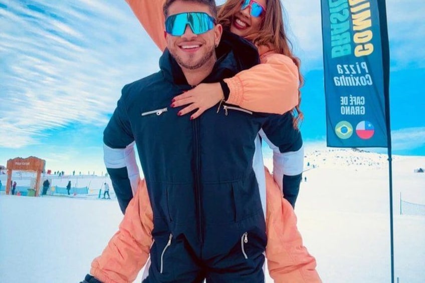 A person carrying another on their shoulders, with a clear sky and a banner in the background. 4