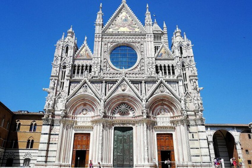 Una catedral gótica con arquitectura elaborada, grandes rosetones y puertas ricamente decoradas. 1