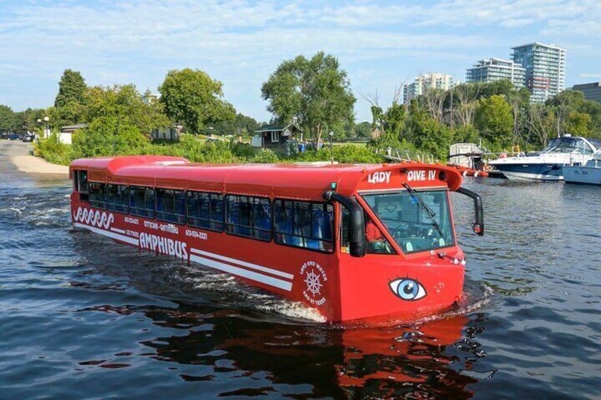 Een rode amfibiebus genaamd 'Lady Dive IV' op het water. 2