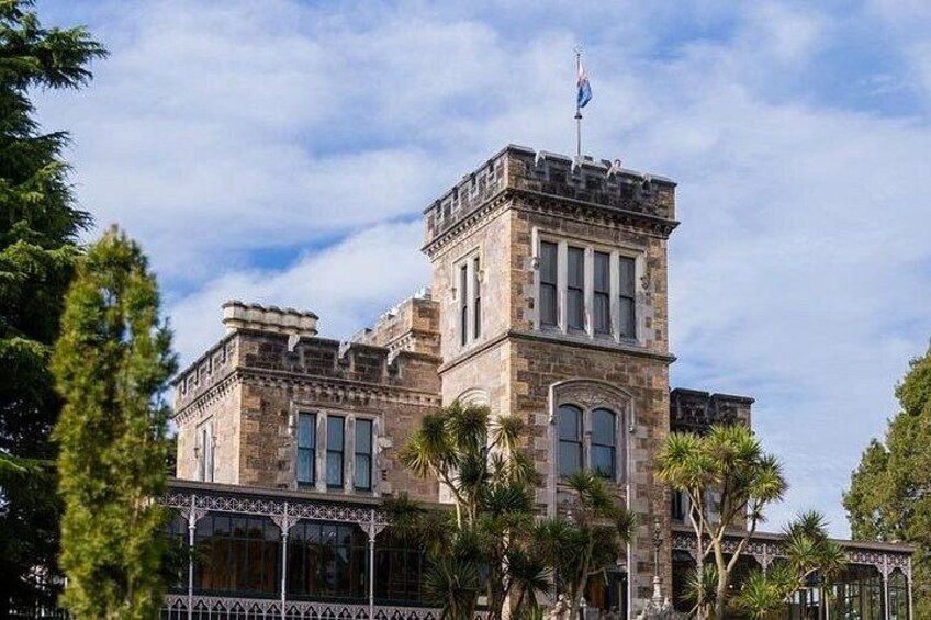 A historic building with a tower, surrounded by palm trees and a clear sky. 2