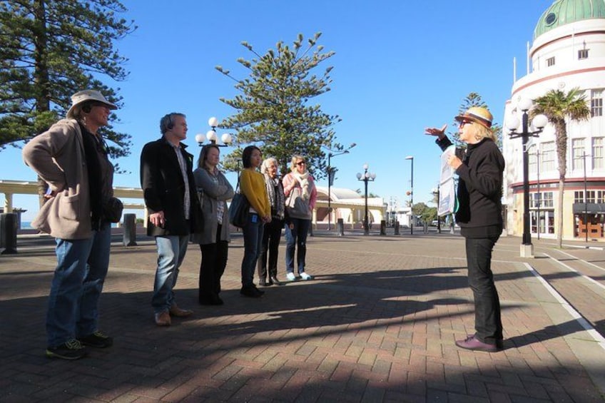 Un grupo de personas de pie en una zona pavimentada, con un edificio grande al fondo. 4