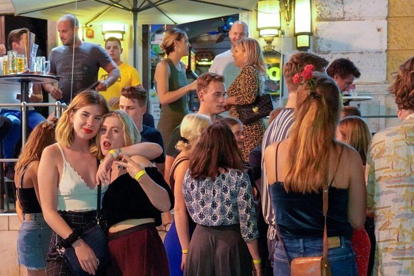 A group of people gathered outdoors, possibly at a social event or market. 3