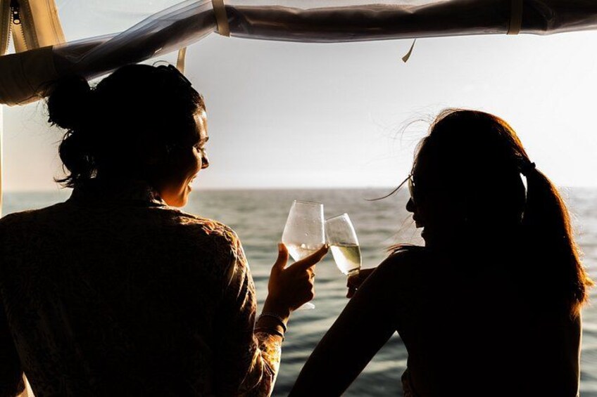 Dos personas sentadas junto a una ventana en un barco, sosteniendo copas de vino. 4