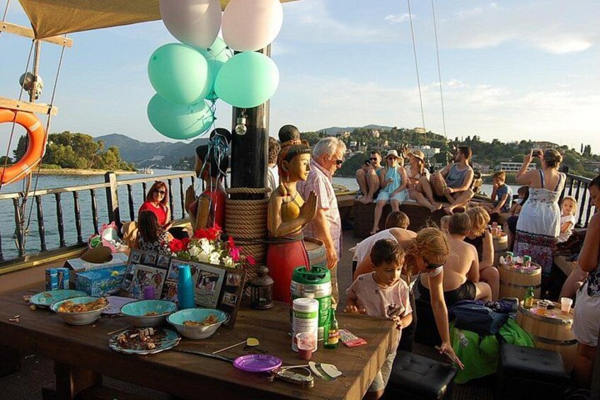 Un événement en plein air très fréquenté, où les gens se sont rassemblés autour de tables, de ballons et de divers objets à bord d’un bateau. 3