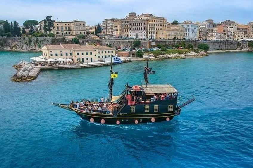 Un bateau transportant des passagers, une ville côtière et une mer bleue et limpide. 1