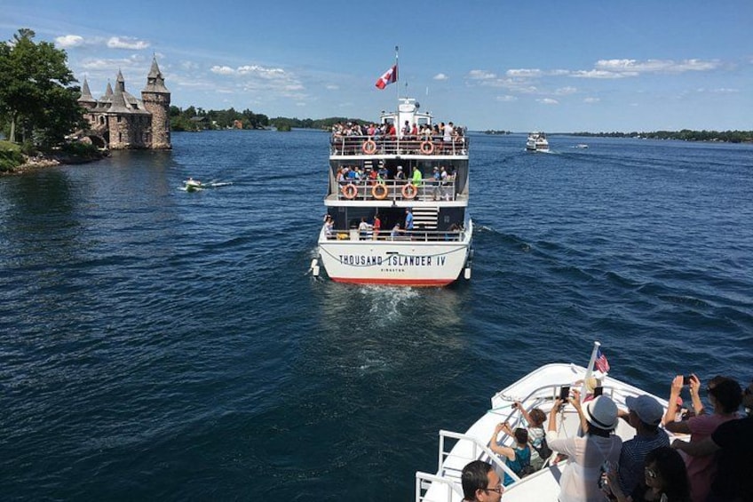 Un gran barco llamado 'Thousand Island IV' con pasajeros, un castillo al fondo y otro barco a lo lejos. 3