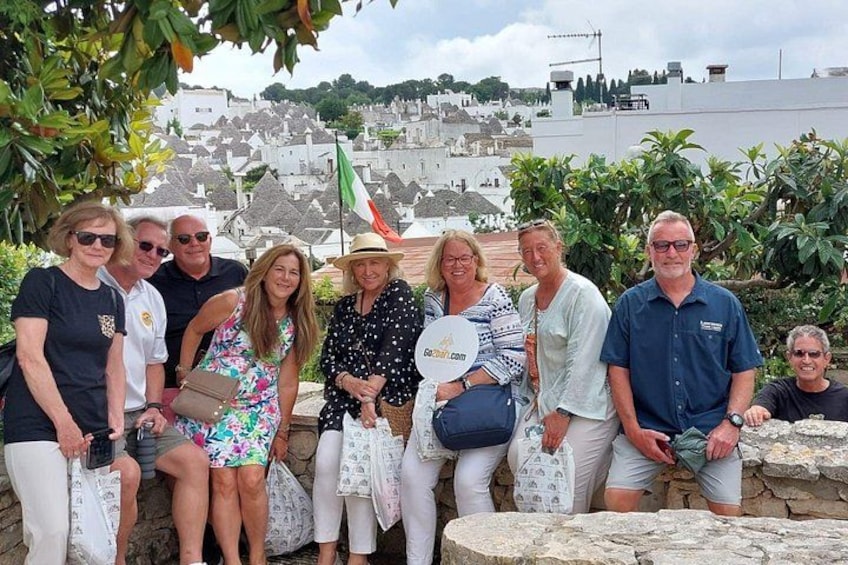 A group of people sitting on stone steps with a cityscape in the background. 4
