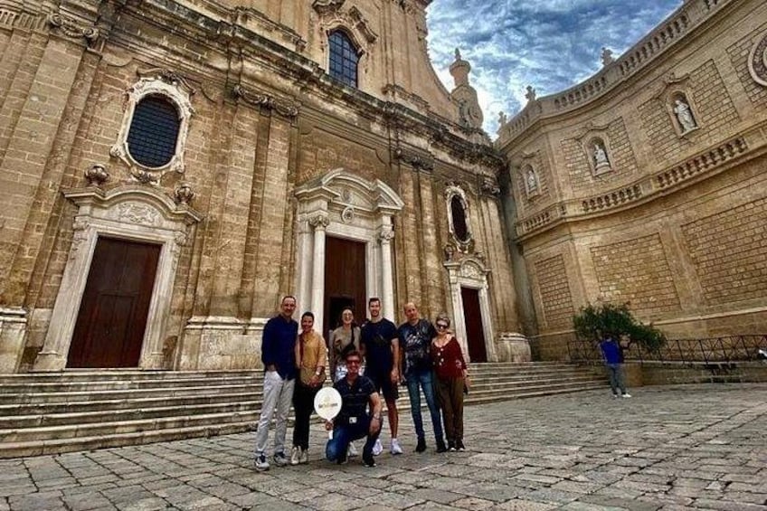 A group of people standing in front of a historic building with ornate architecture. 3