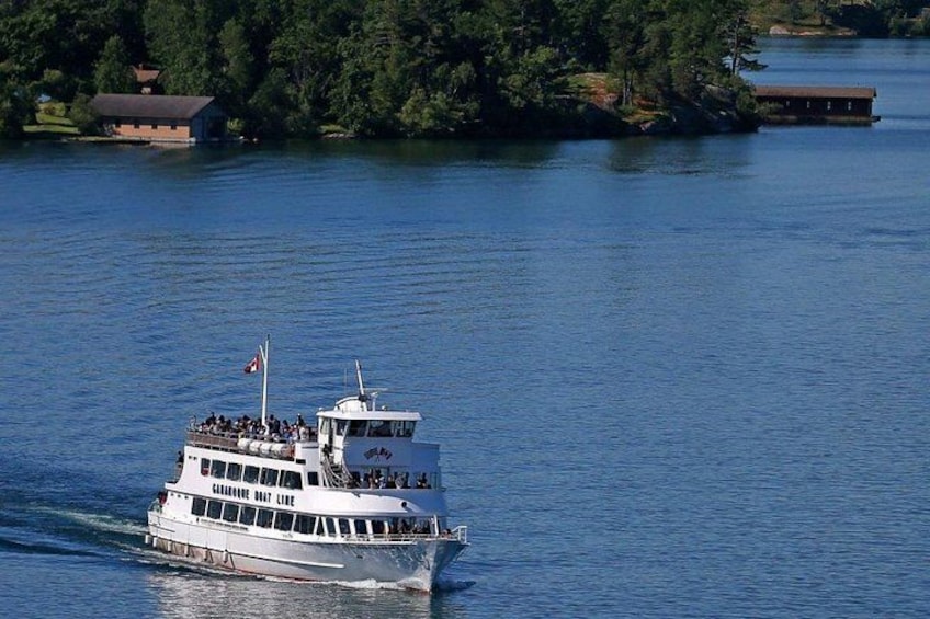Een wit schip met meerdere dekken en een vlag, dat vaart op een rustig wateroppervlak. 2