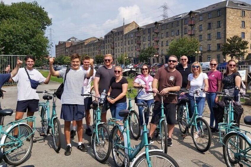 A group of people on bicycles in an urban setting with buildings in the background. 4