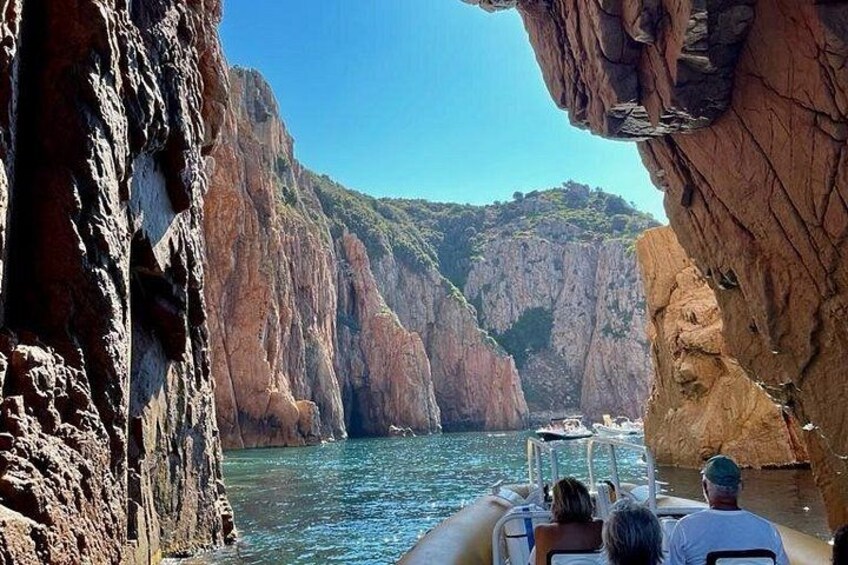 Una embarcación navega por un estrecho cañón de paredes rocosas escarpadas y un río de aguas cristalinas. 2