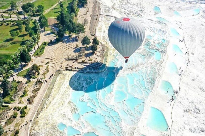 Une montgolfière survolant un paysage composé de terrasses avec des bassins et un parc. 1