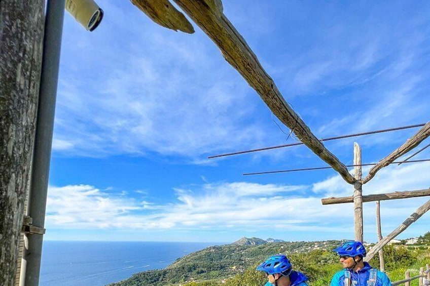 Paisaje costero con cielo despejado, una estructura de madera y dos personas usando cascos. 5