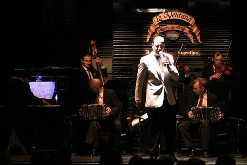 A band performing on stage with a sign reading 'La Ventana.' 3