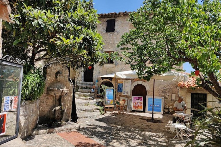Une cour avec des murs en pierre, un arbre et des sièges extérieurs. 3