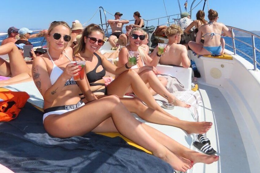 People on a boat with a blue sky and water in the background. 4